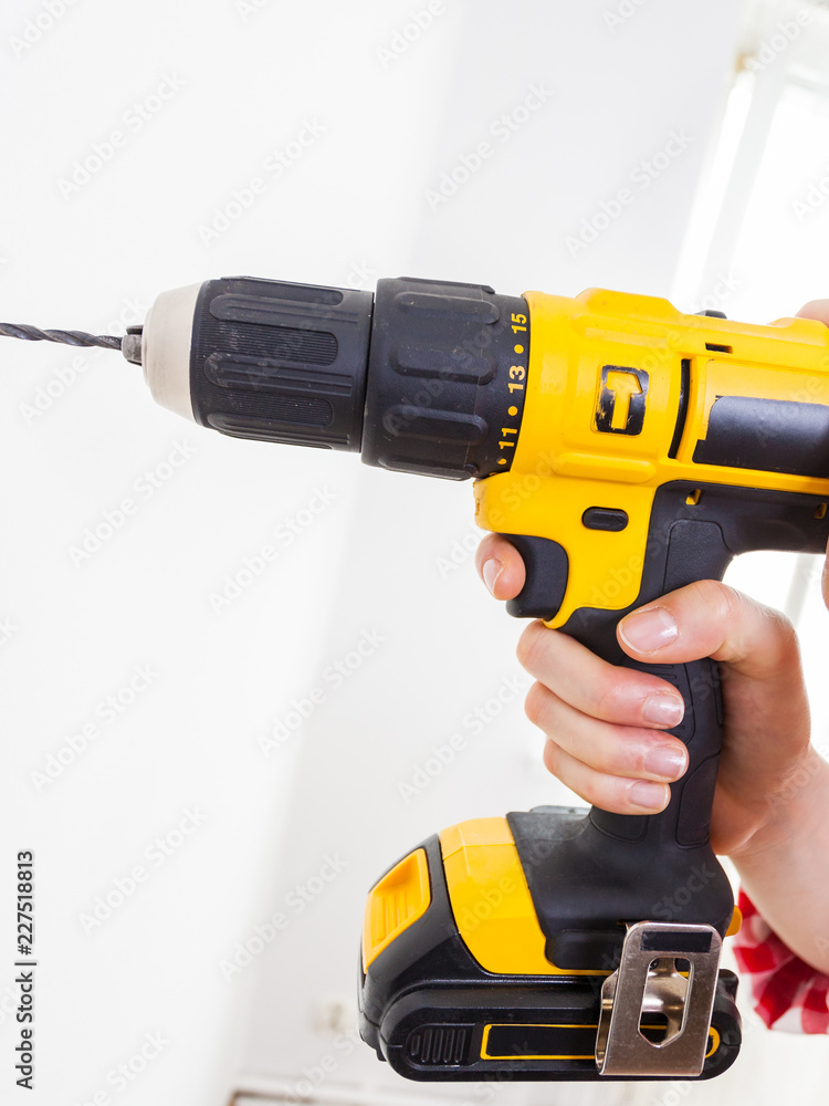 Hand holding yellow drill
