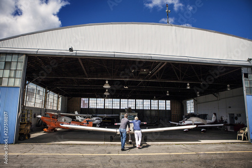 Bild auf Leinwand Men repairing propeller airplane in hangar