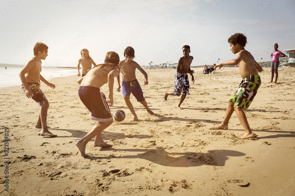 Obraz premium Friends playing soccer at beach