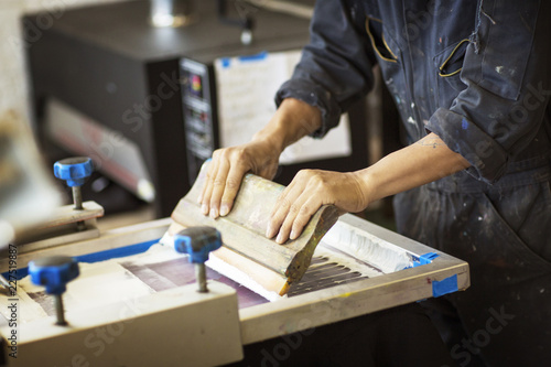 Quadro em tela Midsection of worker pressing ink on frame in workshop