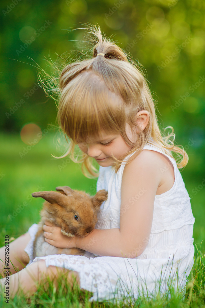Girl with a cute little rabbit, outdoor, summer day Girl with a cute little rabbit, outdoor, summer day