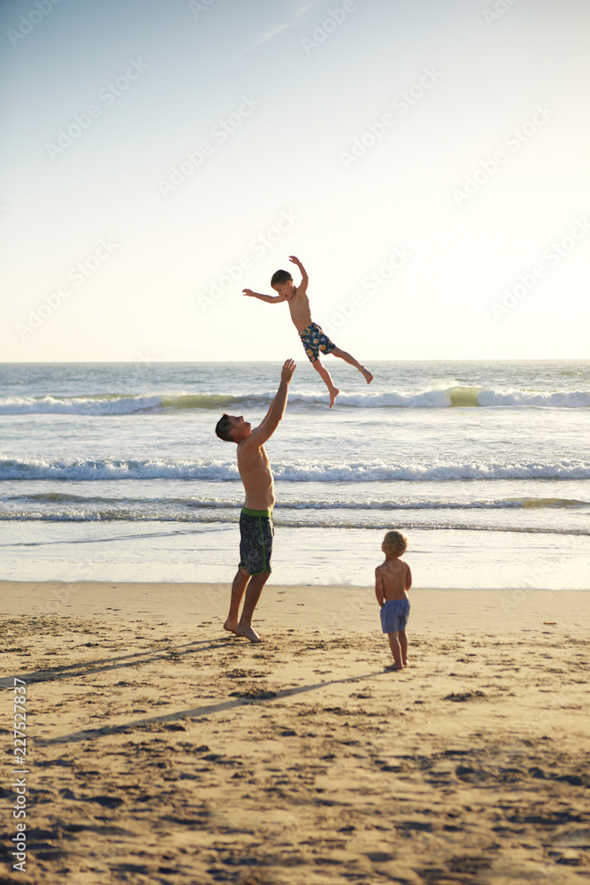 Obraz premium Father playing with son on beach