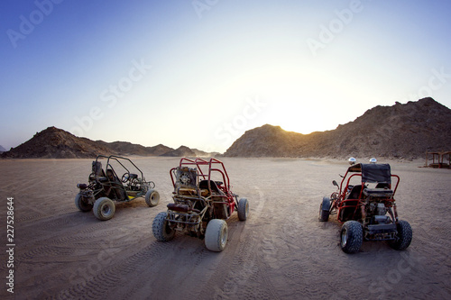 Fotografie Beach buggies in barren landscape at sunset