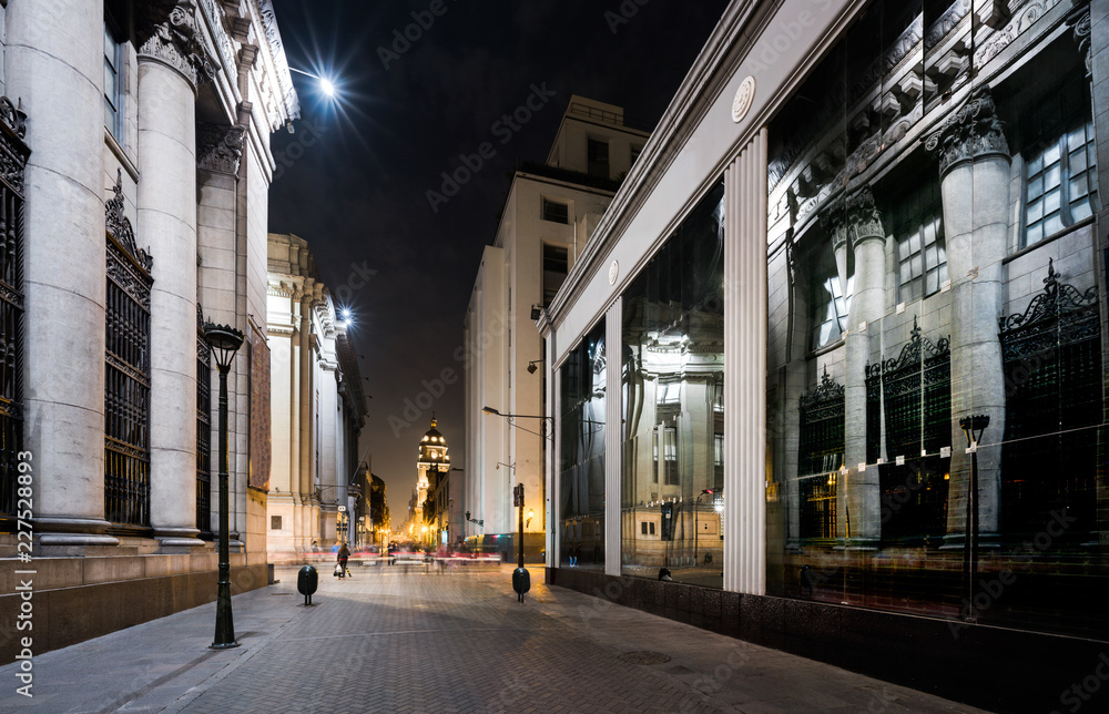 LIMA PERU: NIght view of Ucayali Street at night wit reflect of an classic building in the glass.