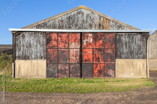 Old barn with metal doors, rusty and red photo