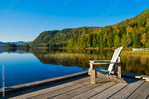Obraz na płótnie Wooden chair on lakeside pier