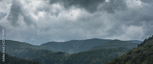 Thick clouds over the mountains with forest