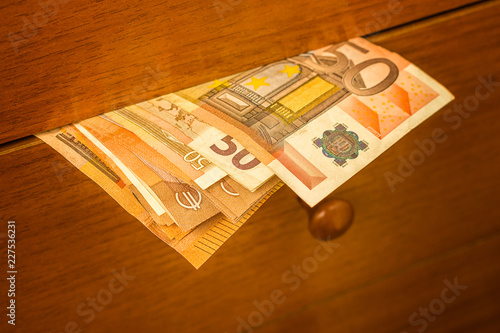 euro banknotes coming out of a drawer