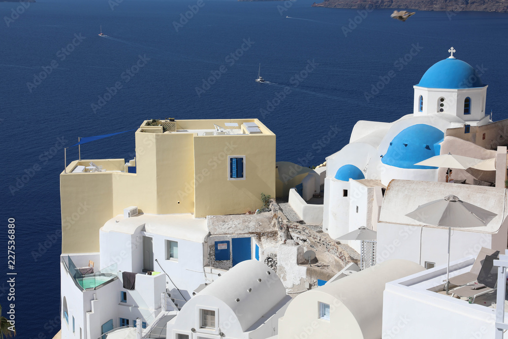 Stunning panoramic view of Santorini island with white houses and blue domes on famous Greek resort Oia, Greece, Europe. Traveling concept background. .