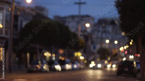 Bokeh night shot of cars driving down residential street in San Francisco