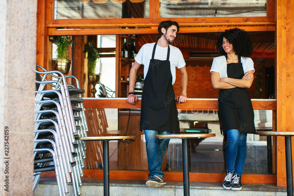 Portrait of waiters in front of a restaurant.