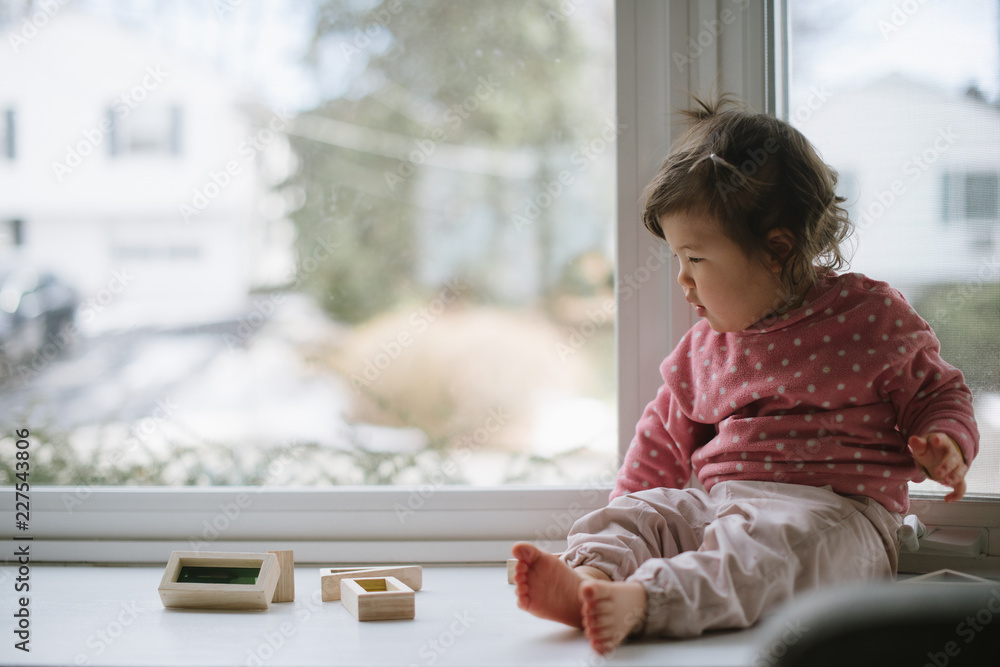 Little baby playing with blocks by window Little baby playing with blocks by window