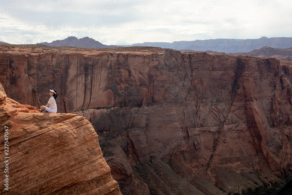 Woman sitting on the edge of the Glen Canyon.