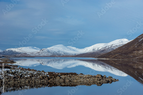 Mountains reflected in icy water in the Scottish Highlands © Callum