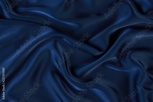 Dark blue silk fabric background, view from above. Smooth elegant blue silk or satin luxury cloth texture can use as abstract background with copy space, close-up 