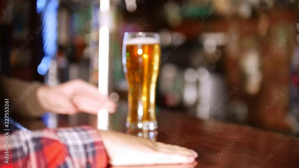 Bartender passes the drink to the customer across the table. Customer catches it Bartender passes the drink to the customer across the table. Customer catches it