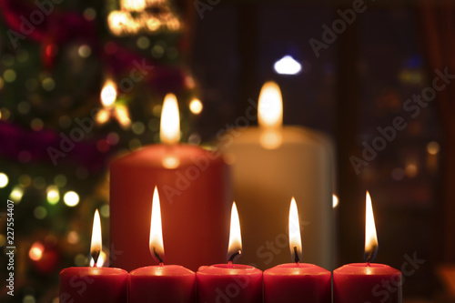 Christmas candles with blurred Christmas tree