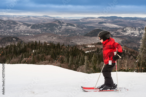 Boy in red ski jacket bravely takes on a steep slope photo