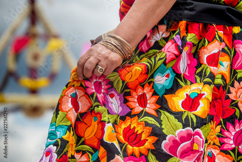 Mujer oaxaqueña con falda bordada y mano con pulsera de oro y anillos bailando en la guelaguetza  photo