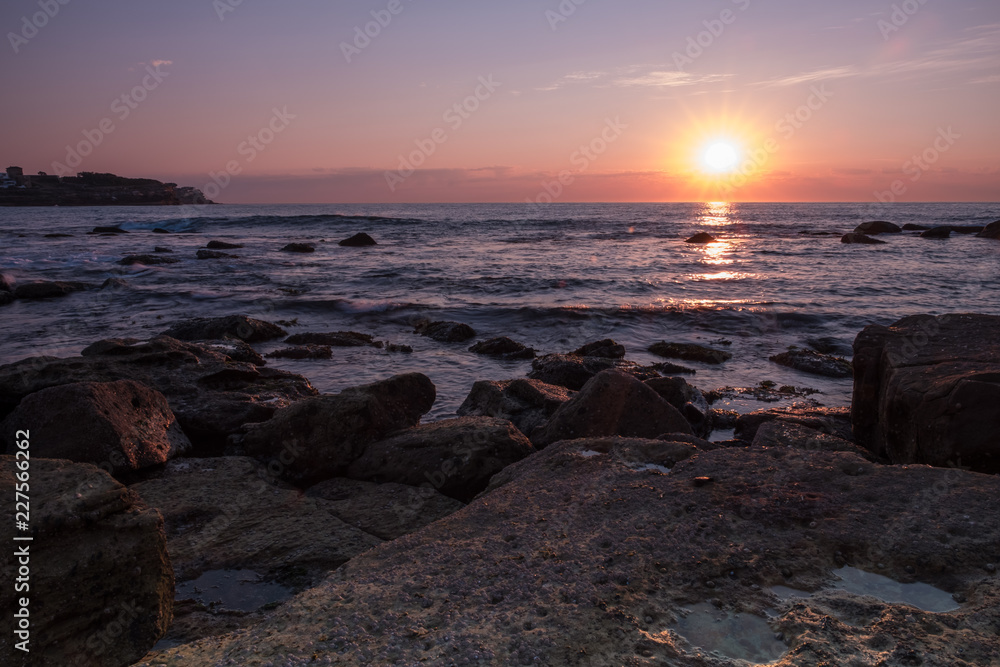 sunrise over water sea side rocks