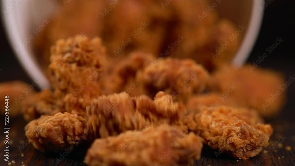 Tub of chicken wings tilting and falling Tub of chicken wings tilting and falling
