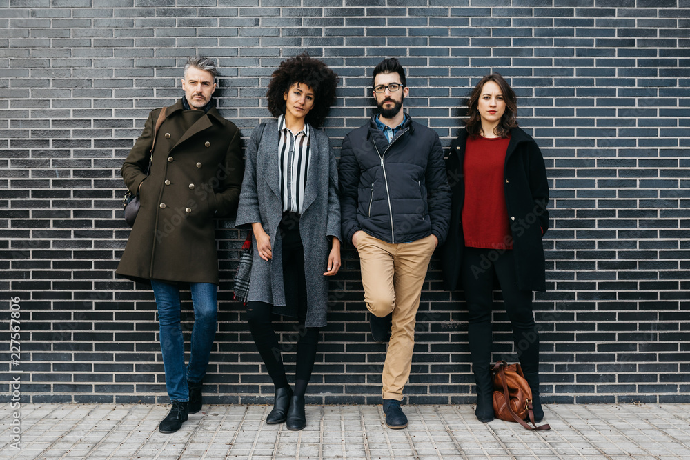 © guillefaingold/Stocksy - Casual stylish people against modern black and white wall in the street. © guillefaingold/Stocksy - Casual stylish people against modern black and white wall in the street.
