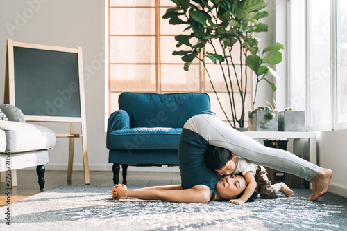 Adorable boy doing yoga with his mother photo