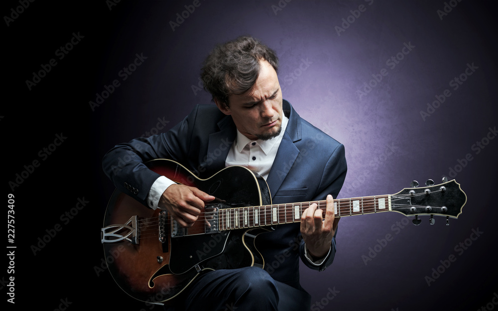 Obraz premium Lonely guitarist composing on cello with nothing around