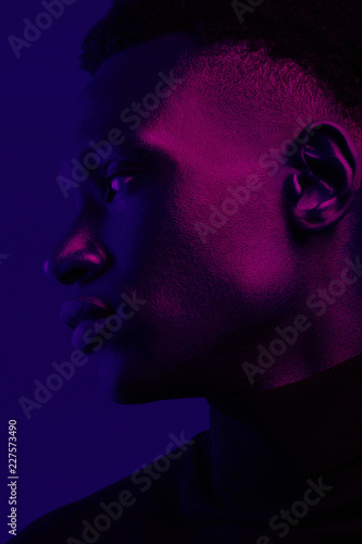 Side view of man under blue and purple light photo