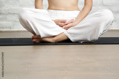 Young woman in the white outfit practicing stretching yoga positions, wellbeing and self care concept