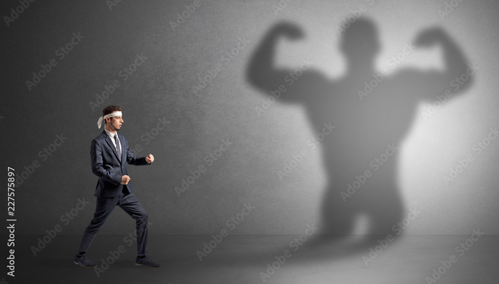 Fototapeta premium Young karate man fighting with a big black scary shadow 