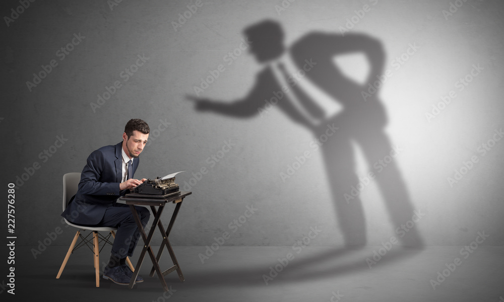 Little man working and a big shadow arguing with him
Little man working and a big shadow arguing with him