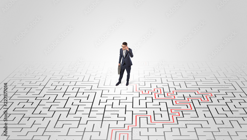 Young entrepreneur standing in a middle of a labyrinth with the solution
Young entrepreneur standing in a middle of a labyrinth with the solution