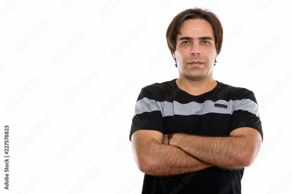 Studio shot of young Persian man with arms crossed Studio shot of young Persian man with arms crossed