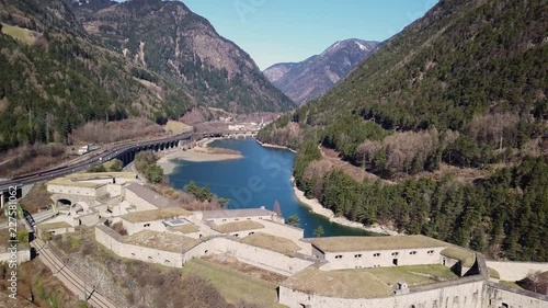 Aerial clip of a fort of the First World Warin the middle of the Alps. Smooth backward camera pan over the buildings. photo