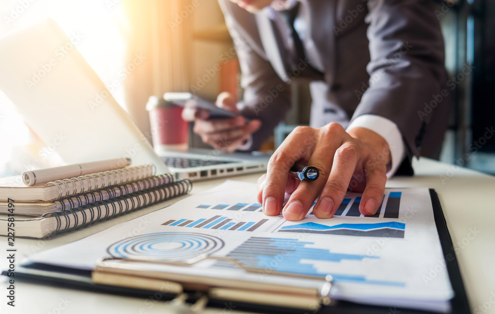 businessman or Designer using tablet with laptop and document on desk in modern office with virtual interface graphic icons network diagram. businessman or Designer using tablet with laptop and document on desk in modern office with virtual interface graphic icons network diagram.