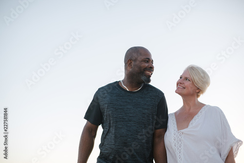 Fun middle aged couple enjoying quality time on the beach at sun photo