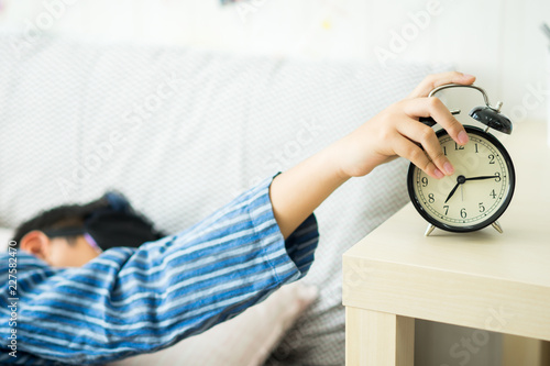 A kids waking up to an alarm clock in the bedroom