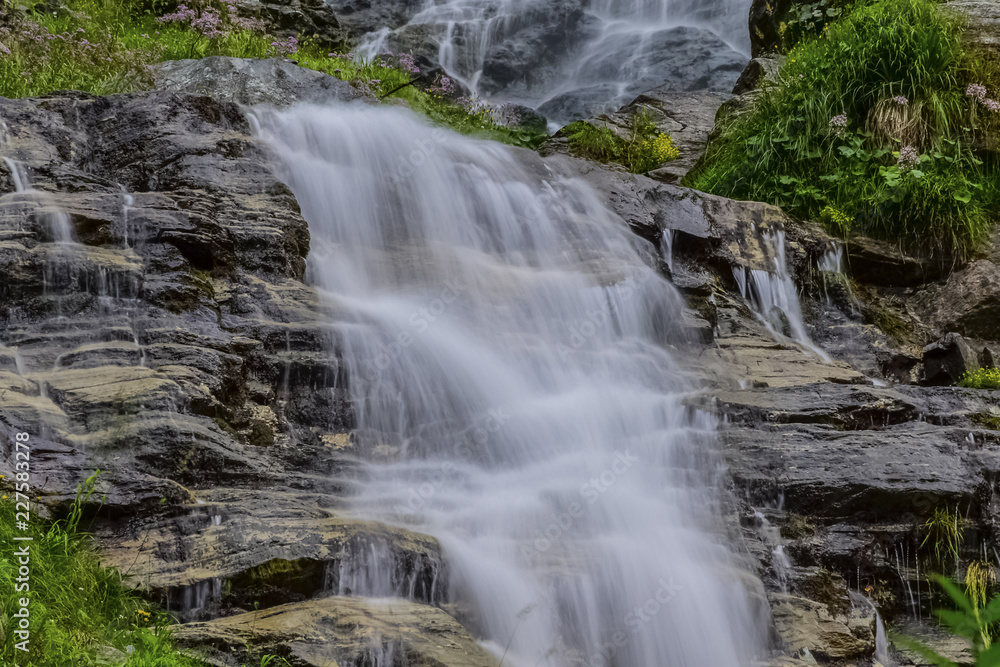 Obraz premium Waterfall in the forest in Austria near Heiligenblut am Großglockner