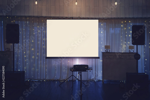Foto Illuminated banquette hall stage with a big white screen and acoustic systems