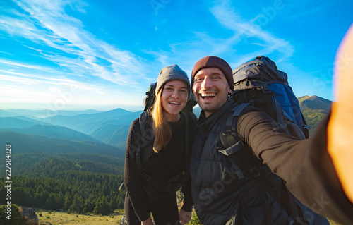 The beautiful couple taking a selfie on the mountain background