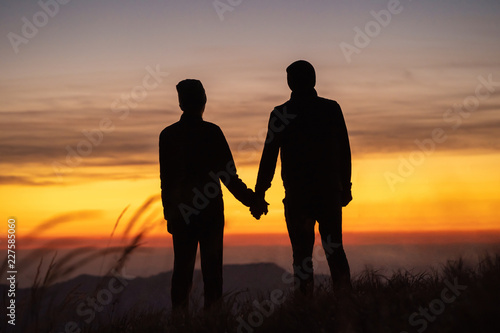 The couple on the mountain enjoying a picturesque sunset background © realstock1