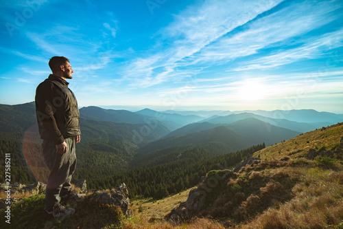 The happy man standing on the beautiful mountain landscape background
