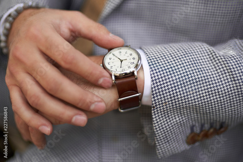 Stylish man checking the time on his watch photo