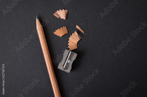 pencil brown wood with sharpening shavings on black craft paper background.  For concept of idea, education