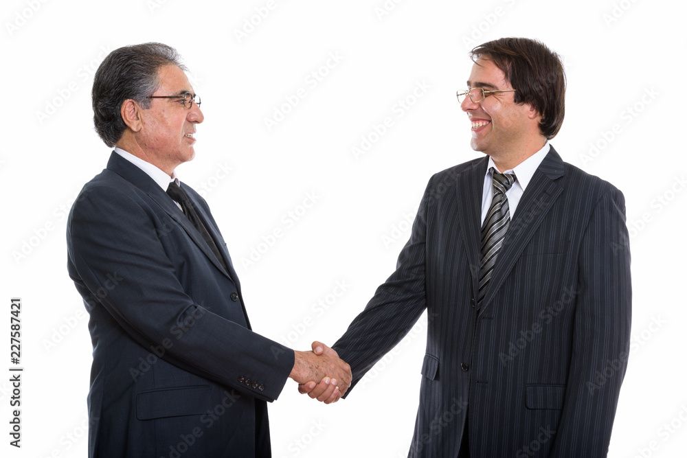 Profile view of happy young and senior Persian businessman smili Profile view of happy young and senior Persian businessman smili
