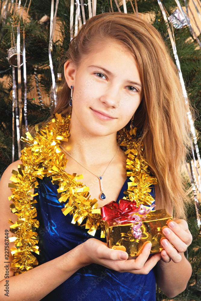 Beautiful happy teen girl holds before itself a Christmas gift