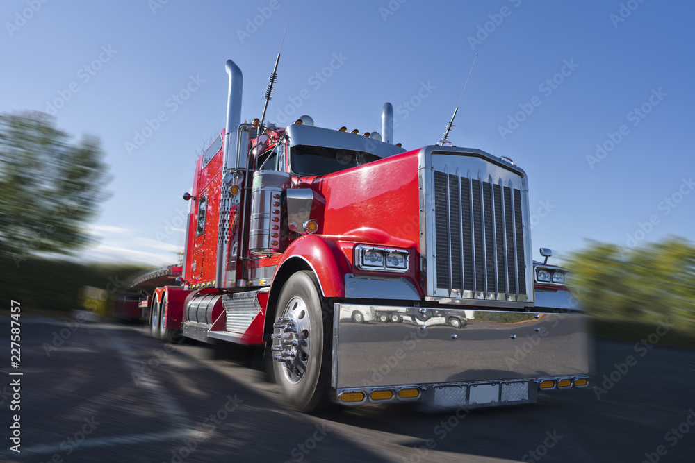 Red classic big rig semi truck with lot of chrome accessories with flat bed  semi trailer stand on truck stop Stock Photo | Adobe Stock