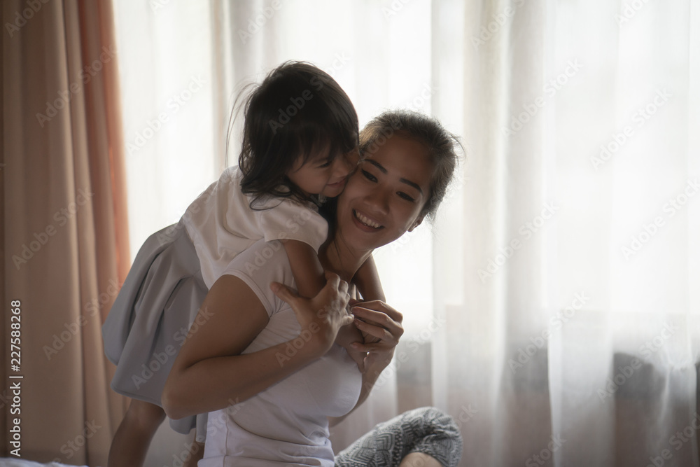portrait mother and her daughter hugging at a bedroom portrait mother and her daughter hugging at a bedroom