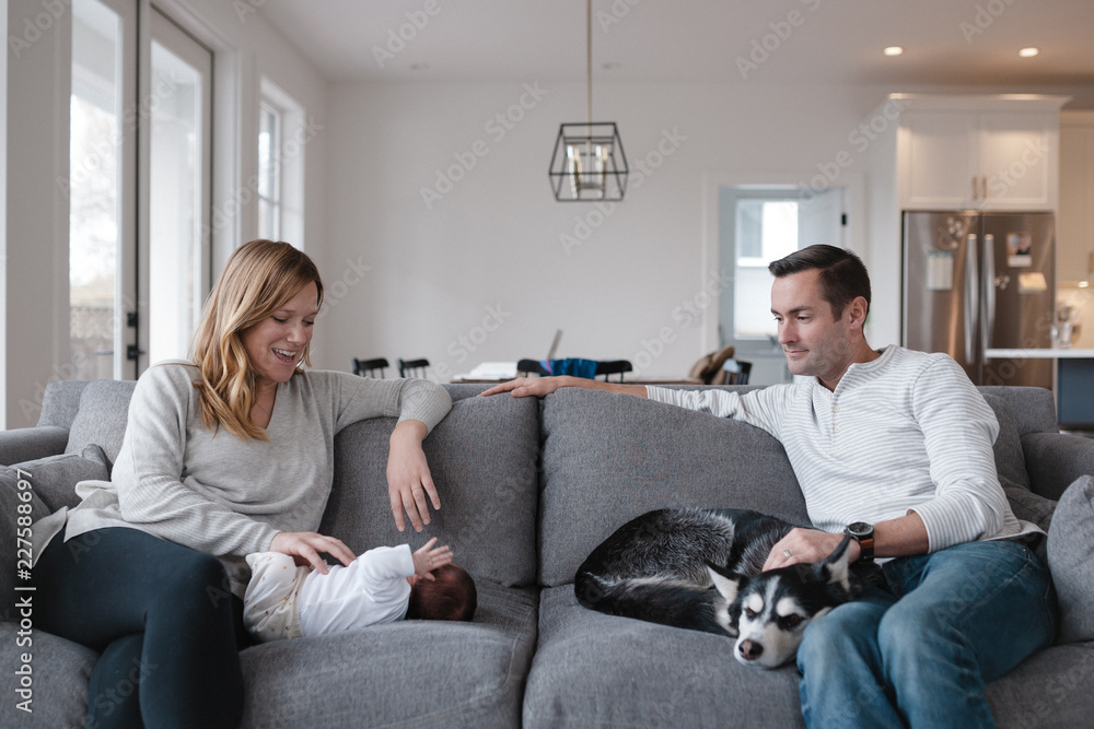 New family of three sitting on the couch together at home New family of three sitting on the couch together at home